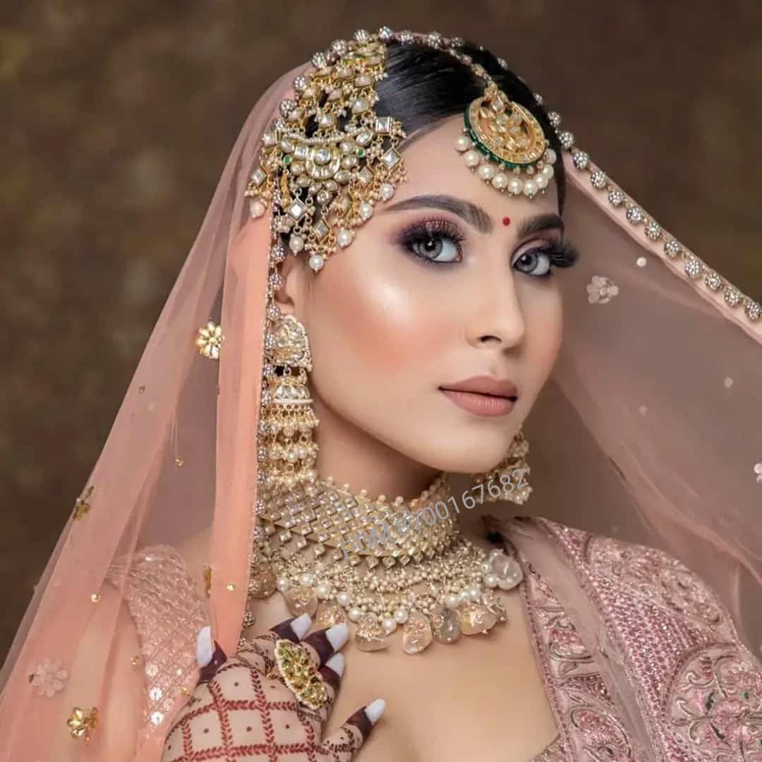 Bridal glam with peach dupatta, gold jewellery and soft mauve-gold eye makeup
